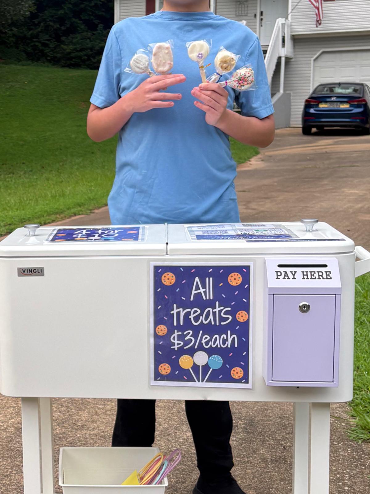 Mathias standing behind his outdoor treat stand