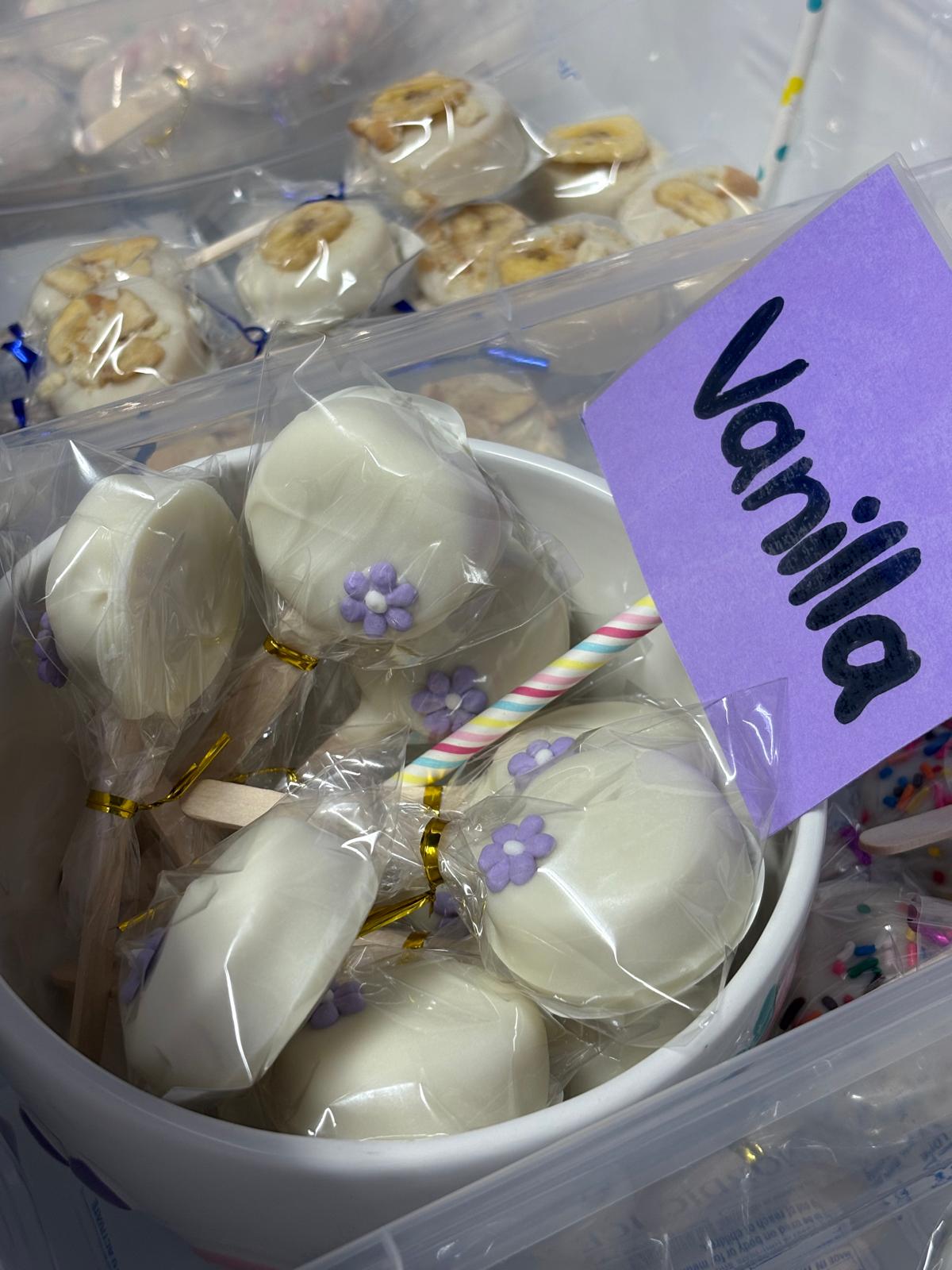 Individually wrapped white cakesicles labeled vanilla